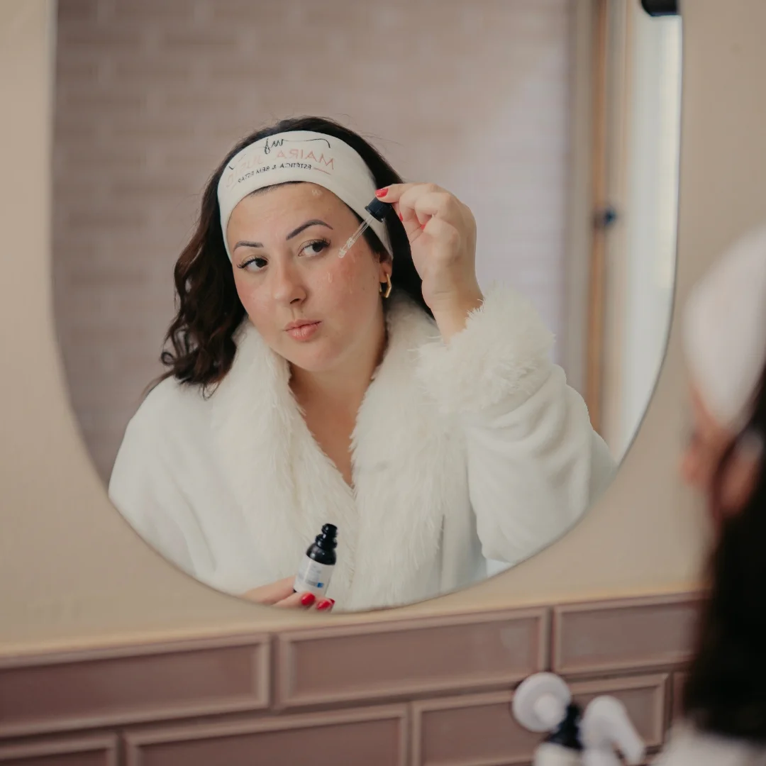Mulher aplicando skincare no espelho